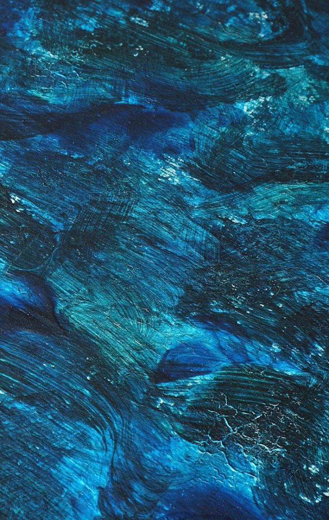 A dynamic abstract painting with rich blue tones and textured brushstrokes evokes movement and depth.