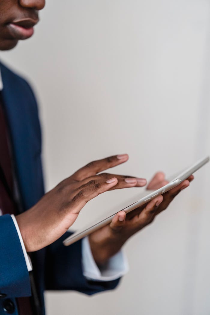 Close-up of a businessman's hands using a digital tablet indoors.